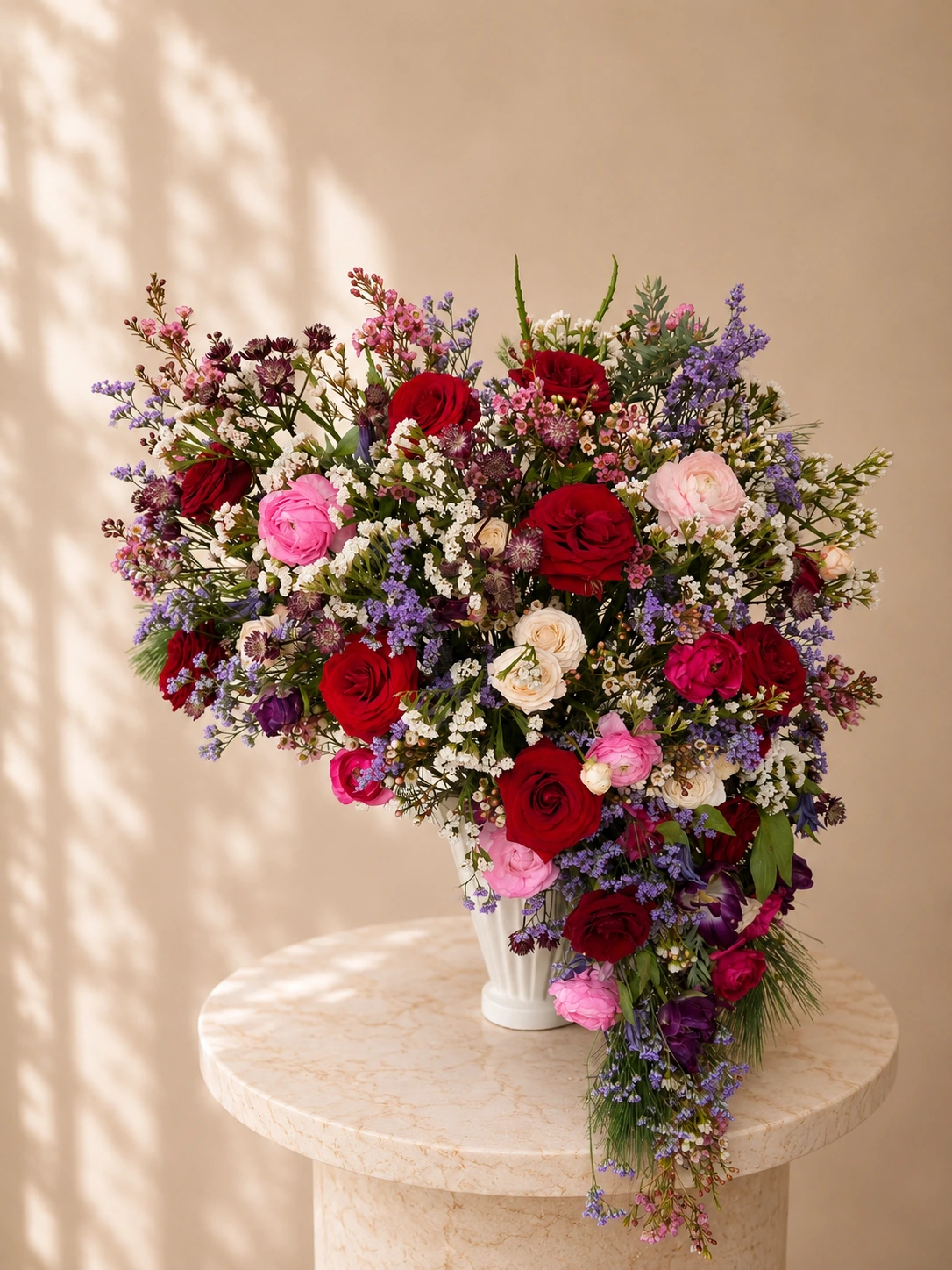 Cascading statement floral arrangement in burgundy, pink and purple for a private event.