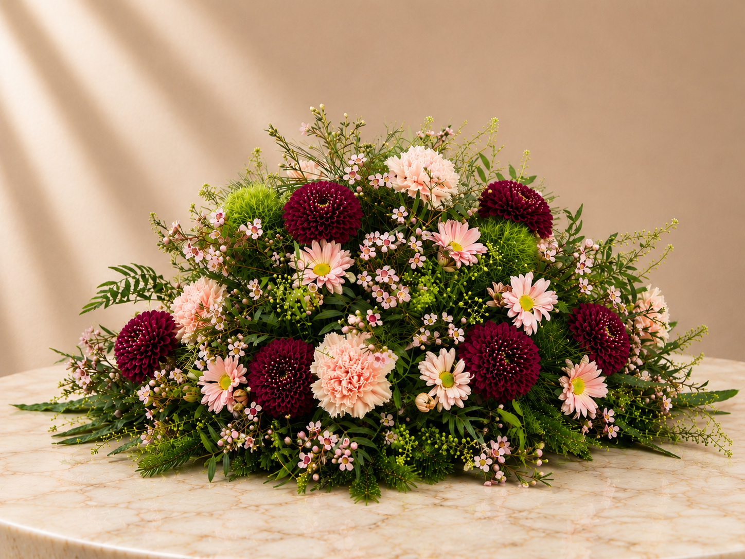 Low floral table centrepiece with burgundy, blush and green seasonal flowers