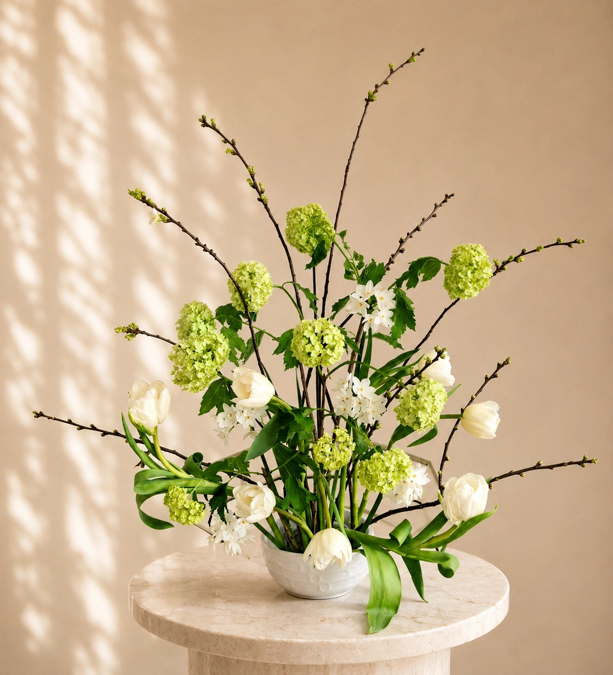 White and green floral arrangement in a fluted ceramic vase with soft natural light
